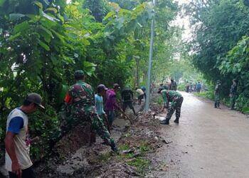 Antisipasi Banjir, Koramil 0812/11 Kedungpring dan Warga Bersihkan Saluran Irigasi Jalan Desa