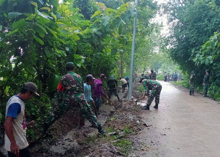 Antisipasi Banjir, Koramil 0812/11 Kedungpring dan Warga Bersihkan Saluran Irigasi Jalan Desa