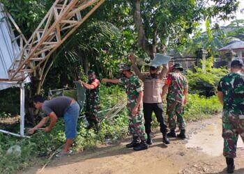 Dengan Sigap Anggota TNI Kecamatan Kedungpring Gotong Royong Bersihkan Puing Gudang yang Diterjang Angin Puting Beliung