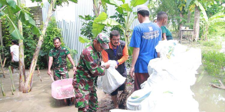TNI di Lamongan Bahu-Membahu Bersama Masyarakat dalam Membuat Tanggul Penahan Banjir