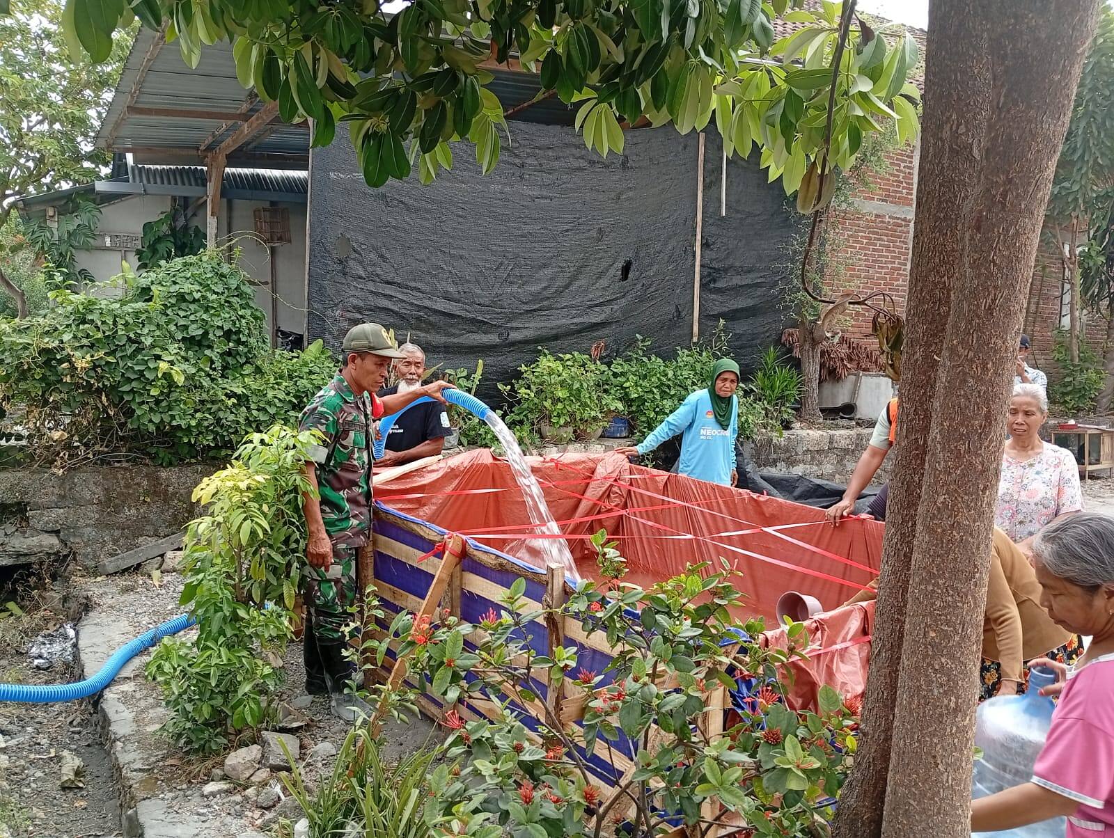 Hadapi Kekeringan, Babinsa Koramil Ngimbang Kawal Distribusi Air Bersih