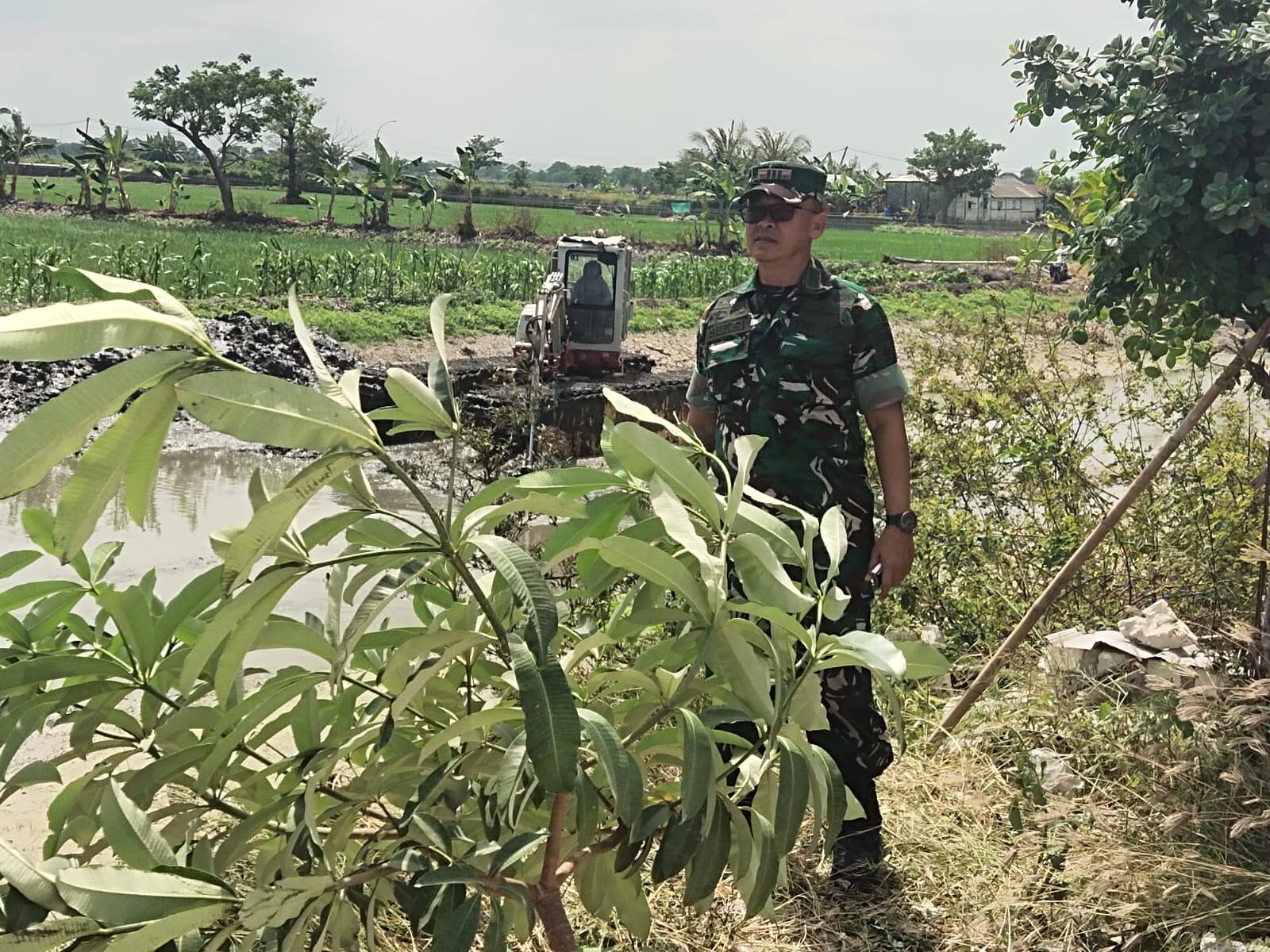 Babinsa 0812/02 Deket Bersama Warga Bersihkan Enceng Gondok di Sungai